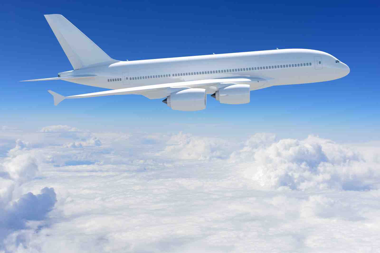 White Airplane Flying Above Clouds Wall Art